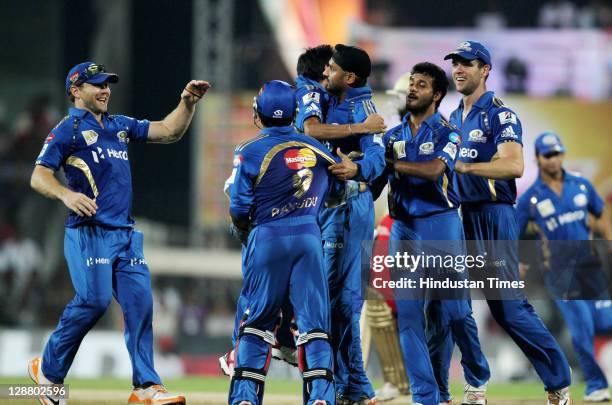Mumbai Indians captain Harbhajan Singh celebrates with team-mates after the dissmisal of Royal Challengers Bangalore batsman Chris Gayle during the...