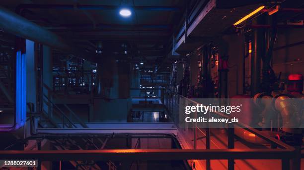 wärmekraftwerk nachts bei rotlicht - district heating plant stock-fotos und bilder