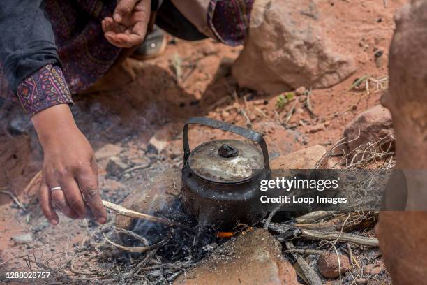Bedouin woman prepares a pot of tea for thirsty travellers in Petra in Jordan.