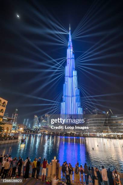 Crowds hold out phones to capture the awe-inspiring light show of the Burj Khalifa in Dubai.