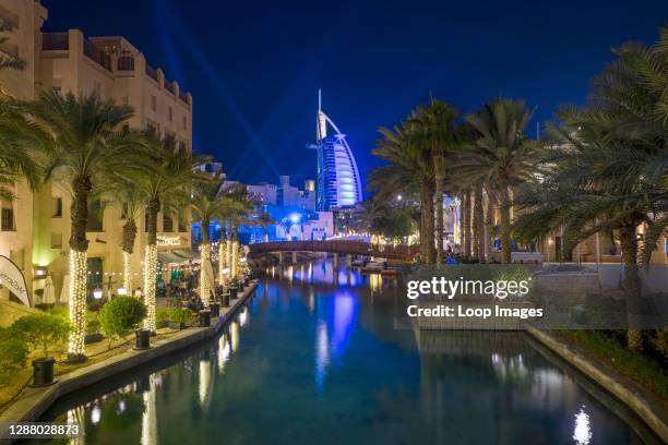 The Burj al Arab is illuminated in beams of light in Souk Madinat Jumeirah.