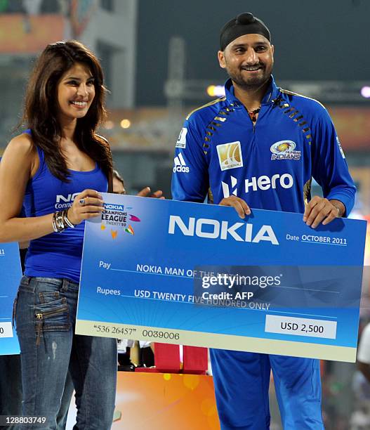 Champions League Twenty20 Man of the match Harbhajan Singh collects his award from Indian Bollywood actress Priyanka Chopra during the presentation...