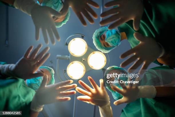 surgeons standing above of the patient before surgery - operationstisch stock-fotos und bilder