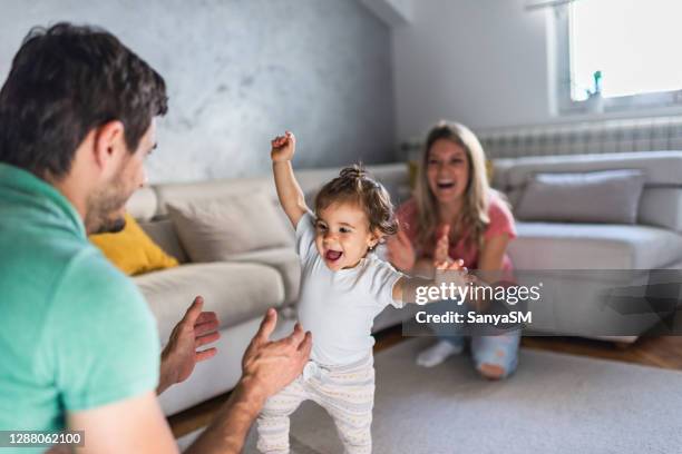 primeros pasos de nuestro bebé - mum dad and baby fotografías e imágenes de stock