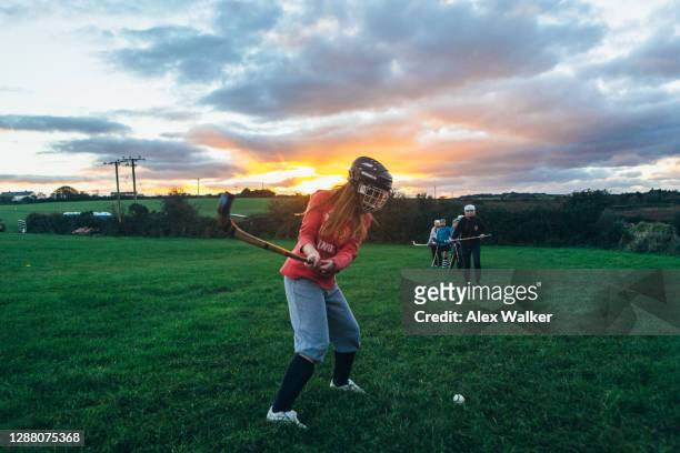 female shinty player warming up at sunset - england hockey women stock pictures, royalty-free photos & images
