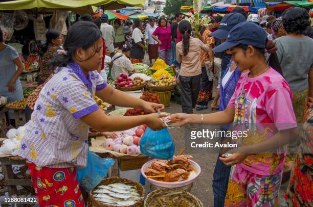 People selling produce and fresh fish on the Russian Market in Phnom Penh, the capital city of Cambodia.