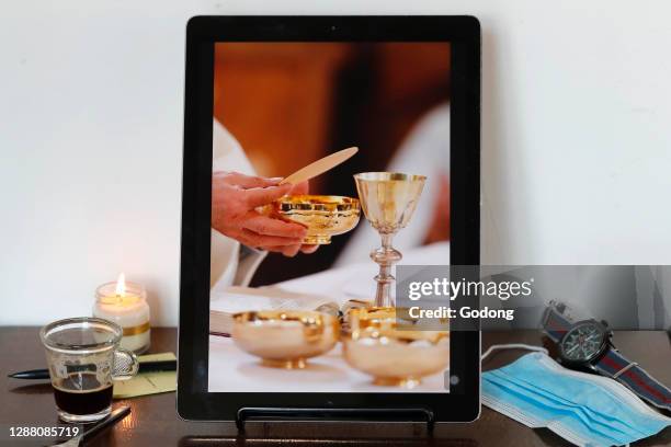 Coronavirus epidemic . Catholic mass on smartphone. Eucharist celebration. France.