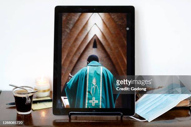 Coronavirus epidemic . Catholic mass on smartphone. Eucharist celebration. France.