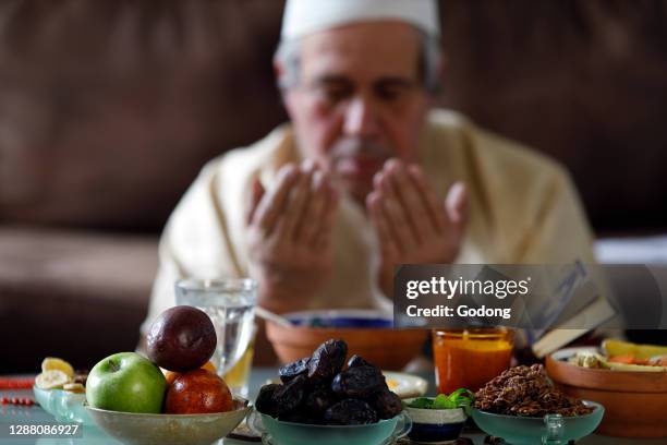 Traditional meal for iftar in time of Ramadan after the fast has been broken. Muslim praying. France.