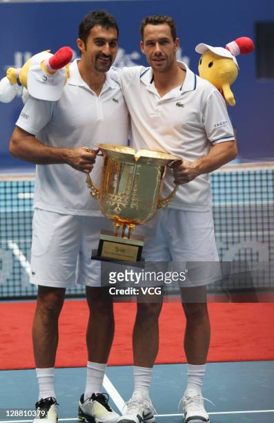 Nenad Zimonjcic of Serbia and Michael Llodra of France pose for photographers after defeating Robert Lindstedt of Sweden and Horia Tecau of Romania...