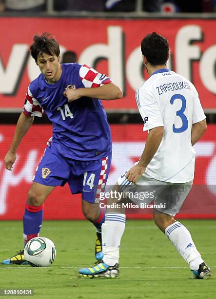 Nikola Kalinic of Croatia dribbles by Giannis Zaradoukas of Greece during the UEFA Euro 2012 Qualifying round group F match between Greece and...