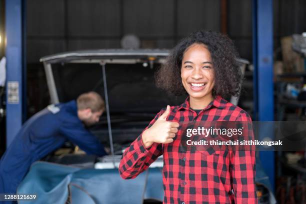 shot of customer woman gives auto mechanic happy thumbs-up for great service. - great customer service stock pictures, royalty-free photos & images