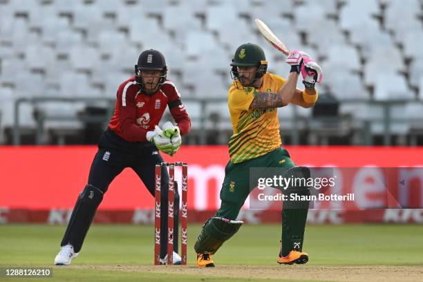 Faf du Plessis of South Africa hits out as wicketkeeper Jos Buttler of England looks on during the 1st Twenty20 International between South Africa...