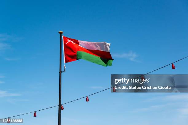 oman flag waving cloudy sky - omani flag stock pictures, royalty-free photos & images