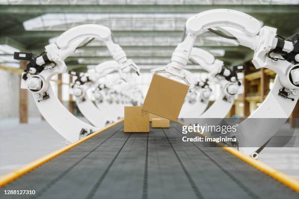 geautomatiseerd magazijn met robotarmen - robot stockfoto's en -beelden
