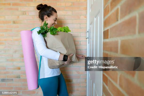 woman arriving home with the groceries after her workout - open workouts imagens e fotografias de stock