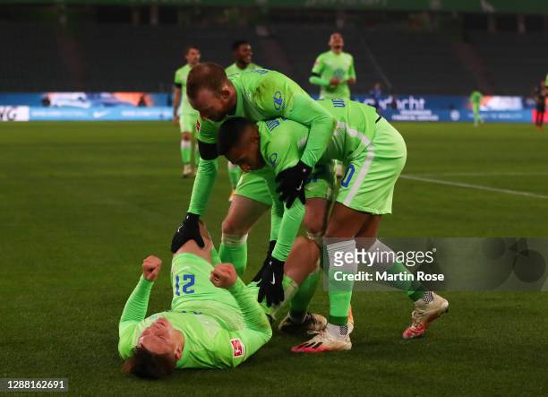 Bartosz Bialek celebrates scoring the fifth goal with Maximilian Arnold and Jérôme Roussillon of Wolfsburg during the Bundesliga match between VfL...