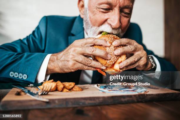 senior geschäftsmann am restauranttisch - burger portrait stock-fotos und bilder