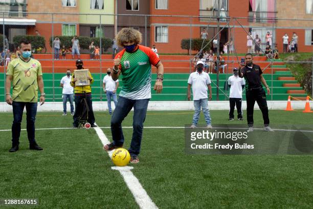 Carlos Valderrama known as 'El Pibe' former football player and captain of the Colombian national team kicks the ball during the re-inauguration of...