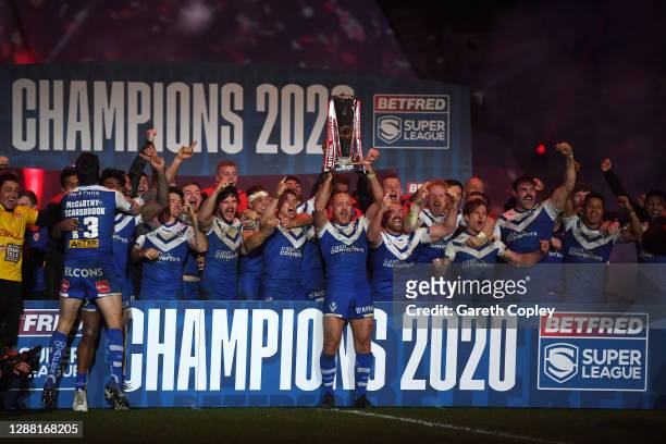 James Roby of St Helens lifts the trophy as his team mates celebrate victory following the Betfred Super League Grand Final between Wigan Warriors...