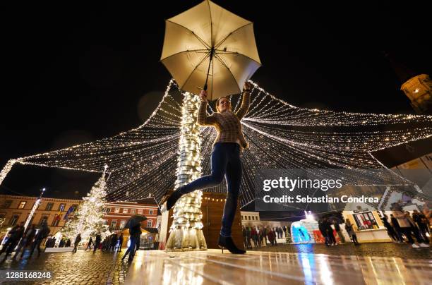 woman with umbrella enjoying christmas decorative lights, holidays 2020. - cluj napoca imagens e fotografias de stock