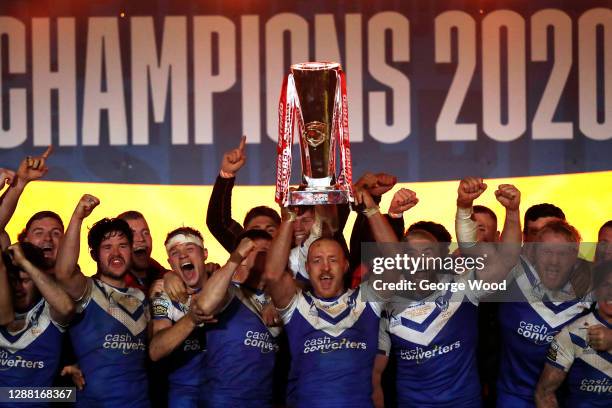 James Roby of St Helens lifts the trophy as his team mates celebrate victory following the Betfred Super League Grand Final between Wigan Warriors...