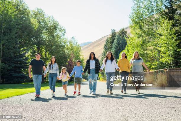 family members holding hands walking down street - ketchum idaho stock pictures, royalty-free photos & images