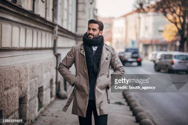 um homem de handosme vestido com roupas quentes de inverno andando ao ar livre na cidade - casaco - fotografias e filmes do acervo