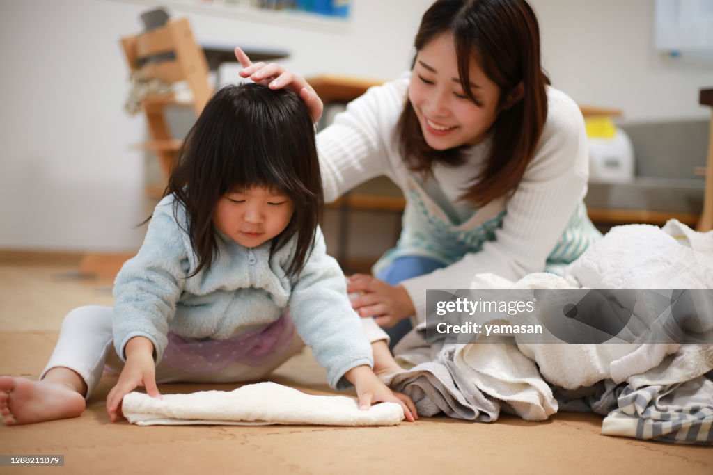 A girl helping to fold the laundry