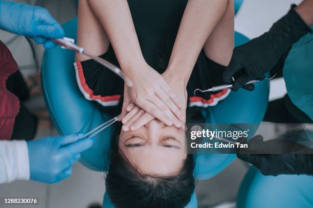 directly above dental examination inspection on chinese teenage girl covering mouth - phobia imagens e fotografias de stock