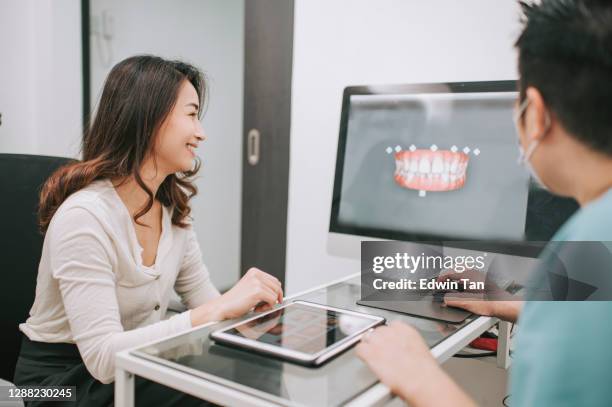 asian chinese male dentist explaining tooth x-rays to a patient - dental tools and computer stock pictures, royalty-free photos & images