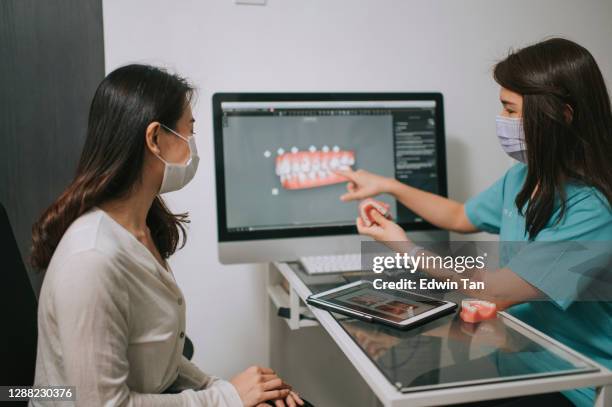 asian chinese female dentist explaining tooth3d to a patient - implante imagens e fotografias de stock