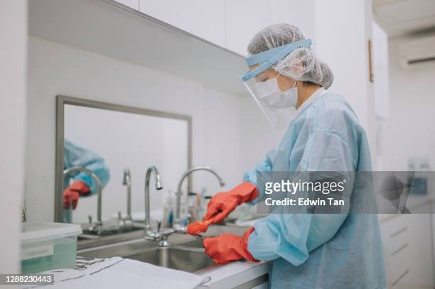 asiática enfermera china con ppe protector ropa de trabajo limpiando herramientas de cirugía - instrumento médico fotografías e imágenes de stock