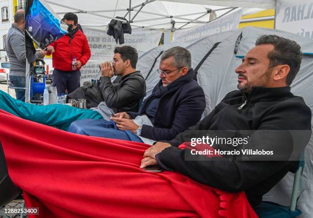 Members of the "A Pão e Água" movement sit in front of tents as they stage a hunger strike outside the Assembleia da Republica to call the...