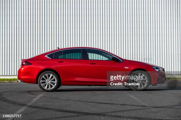 red liftback opel insignia grand sport em um estacionamento - opel - fotografias e filmes do acervo