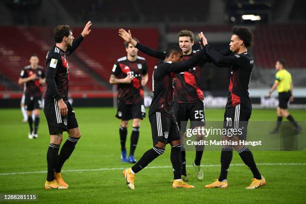 Douglas Costa of FC Bayern Munich celebrates with teammate Leroy Sane after scoring his team's third goal during the Bundesliga match between VfB...