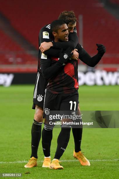 Douglas Costa of FC Bayern Munich celebrates with teammate Leon Goretzka after scoring his team's third goal during the Bundesliga match between VfB...