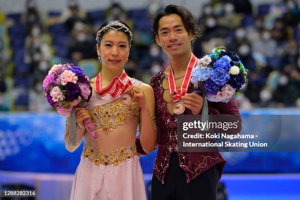 Bronze medalists Kana Muramoto and Daisuke Takahashi of Japan pose for photograpgs on the podium during the medals ceremony of the Ladies Free...