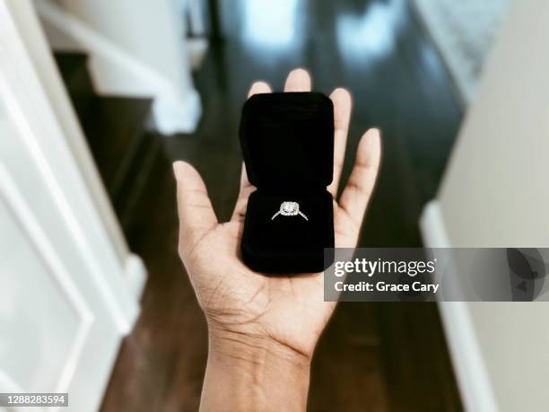 woman holds ring box in palm of hand - ring box stock-fotos und bilder