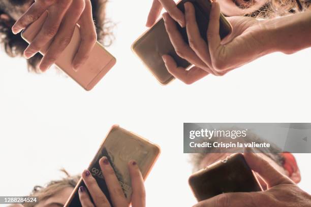hands and mobiles - vier personen stock-fotos und bilder