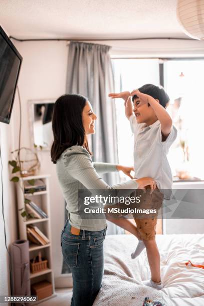 mother helping his son to get dressed - childrens closet stock pictures, royalty-free photos & images