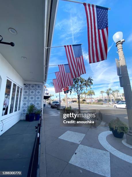 empty newport beach street  with us flags hanging - newport beach california stock pictures, royalty-free photos & images