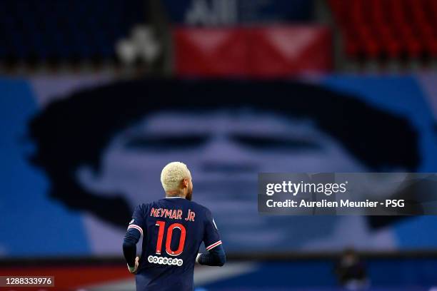 Neymar Jr of Paris Saint-Germain looks on as he runs by a Diego Maradona tifo as a tribute to his death during the Ligue 1 match between Paris...