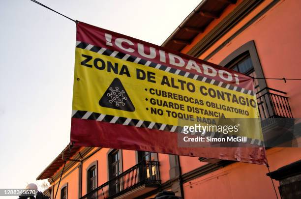 spanish-language covid-19 health and safety sign banner hanging over an outdoor pedestrian shopping mall - veracruz stock-fotos und bilder