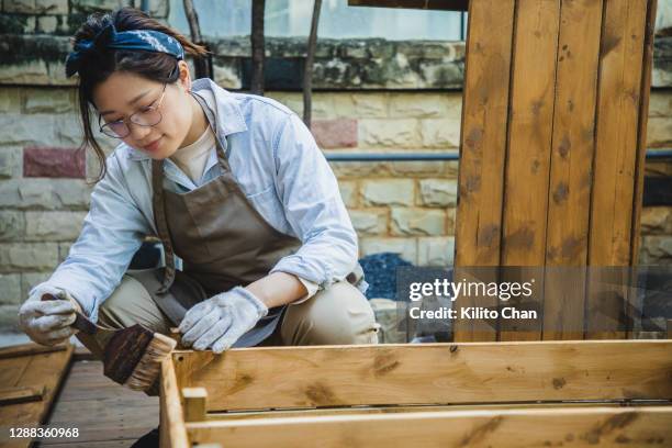 asian woman painting shelf in the yard - making painting stock pictures, royalty-free photos & images