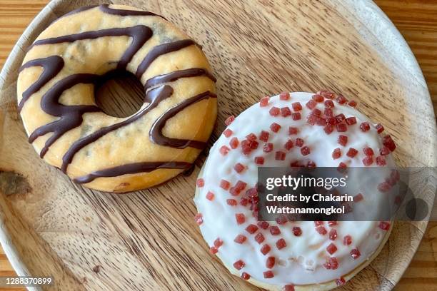 doughnuts (two styles) on a wooden plate, table top view. - ready meal fotografías e imágenes de stock