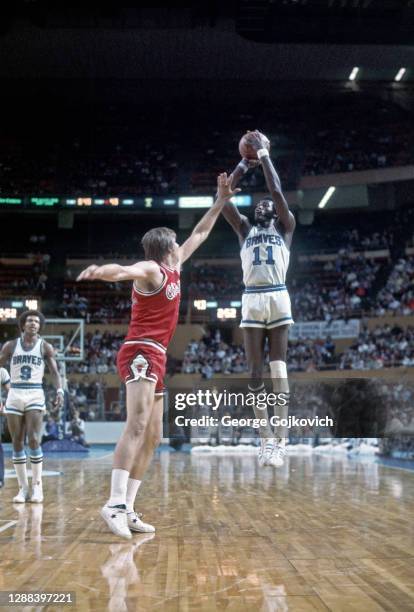 Center Bob McAdoo of the Buffalo Braves shoots against center Tom Boerwinkle of the Chicago Bulls as guard Randy Smith looks on during a National...
