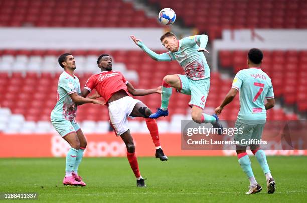 Jay Fulton of Swansea City heads the ball as Kyle Naughton and Korey Smith of Swansea City and Sammy Ameobi of Nottingham Forest look on during the...