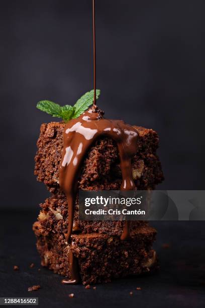 pouring melted chocolate on brownie - pouring chocolate stock pictures, royalty-free photos & images