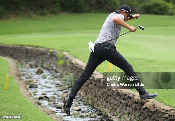 Christiaan Bezuidenhout of South Africa jumps the creek on the 14th hole en route to wining the Alfred Dunhill Championship at Leopard Creek Country...